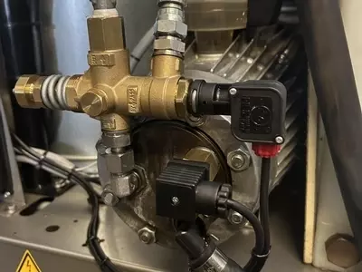 Over-temperature protection system installed on a Nilfisk SH Truck Booster pump to prevent overheating. The system monitors pump head temperature and automatically shuts the machine down if it exceeds safe operating limits, protecting seals and internal c
